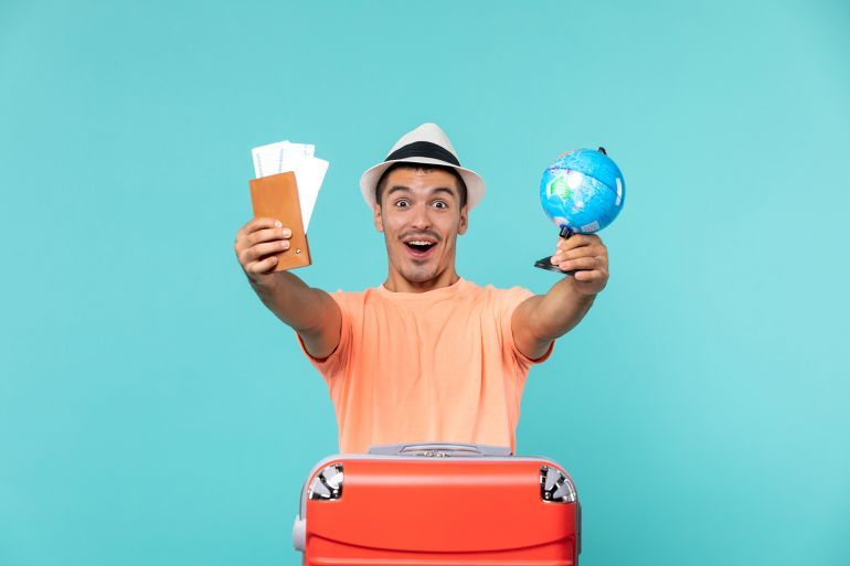 front view male in vacation holding little globe and tickets excited on blue background plane vacation sea trip journey voyage المصدر: فريبيك