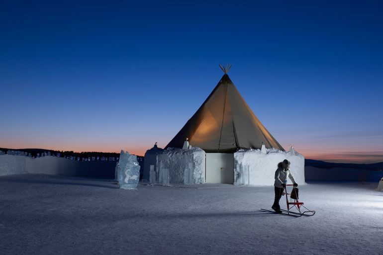 A woman uses a kick sled outside a Saami tent at the Icehotel in Sweden. The Icehotel is constructed each year from 20,000 tons of snow and 3,000 tons of ice.