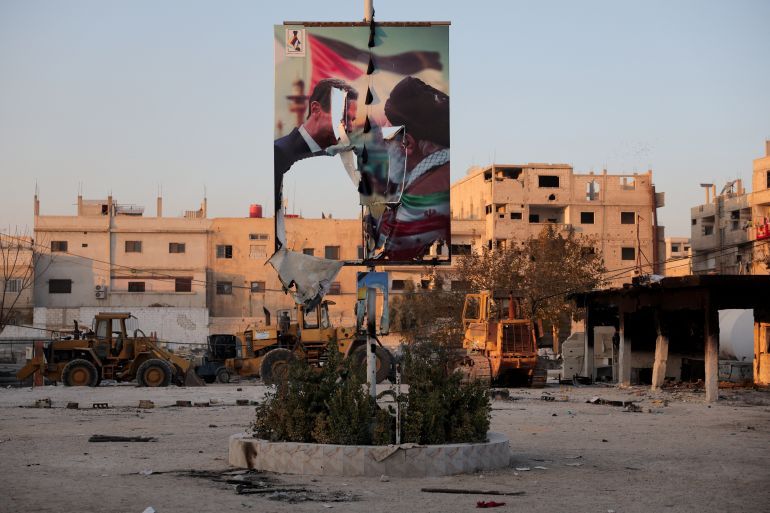 A torn poster showing former Syrian President Bashar al-Assad meeting with Iran's Supreme Leader Ayatollah Ali Khamenei, in the Sayyida Zaynab district in Damascus, Syria, December 14, 2024. REUTERS/Amr Alfiky