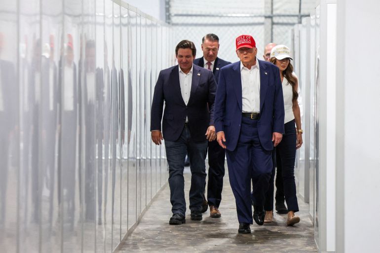 FILE PHOTO: U.S. President Donald Trump, Florida Governor Ron DeSantis and U.S. Homeland Security Secretary Kristi Noem visit a temporary migrant detention center informally known as 