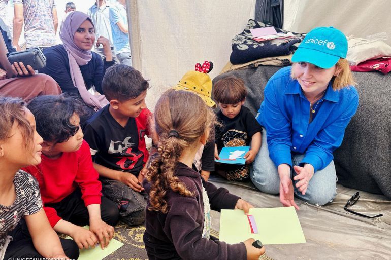 UNICEF Spokesperson Tess Ingram, right, speaks with children who were participating in psychosocial activities with UNICEF partner Tamer, at the Tel al Soltan Stadium Camp on 3 April, 2024, in Rafah, Southern Gaza.