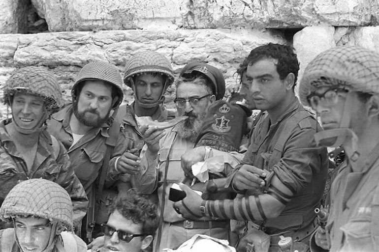 A group of soldiers surrounds then-IDF chief rabbi Shlomo Goren as he blows a shofar at the Western Wall in Jerusalem's Old City on June 7, 1967. (Bamahane Magazine/Defense Ministry's IDF Archive)