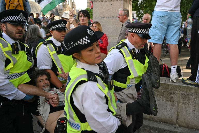 A protester is carried away by police officers at a