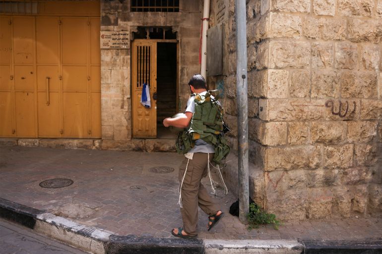 An Israeli settler enters a house at the entrance of the Palestinian market in the old city of Hebron, which was reportedly confiscated the previous night by settlers, on September 3, 2025, in the divided city of Hebron in the occupied West Bank.