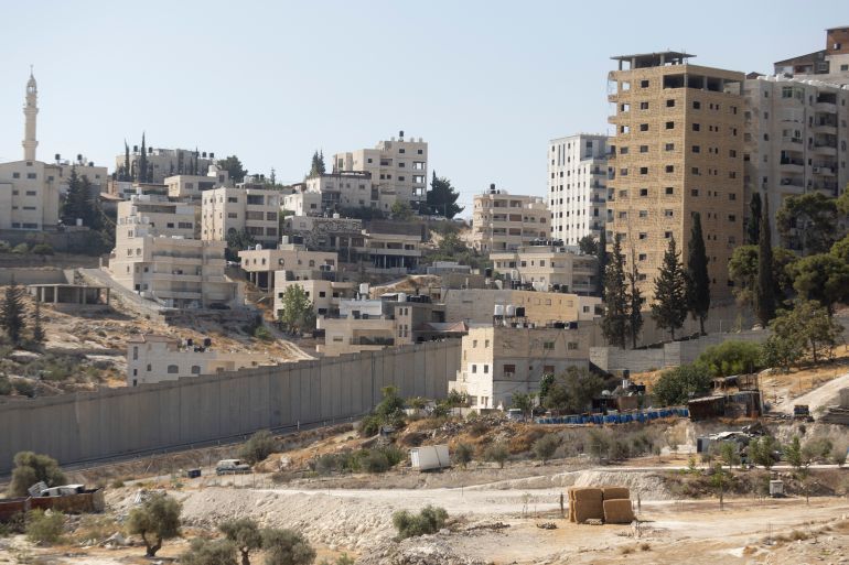 UNSPECIFIED, ISRAEL - AUGUST 22: A view over the separation wall and the Arab village of Al-Eizariya, near where the Israeli government plans to build a new neighborhood as part of E1 settlement project on August 22, 2025 in near Jerusalem, Israel. On Wednesday Israel approved plans put forward by far-right Finance Minister Bezalel Smotrich that would see a new Israeli settlement of 3,400 homes built east of Jerusalem in the E1 zone, effectively bisecting much of the occupied West Bank. Until now construction in the area has been prohibited for two decades, and is considered illegal under international law. The move has been condemned by the international community, with critics accusing Israel of sabotaging any prospect of a future two-state solution. (Photo by Amir Levy/Getty Images)