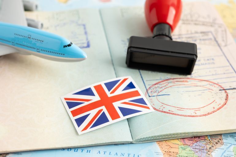 United Kingdom flag with approved Stamp visa and passport document to immigration at airport in country.