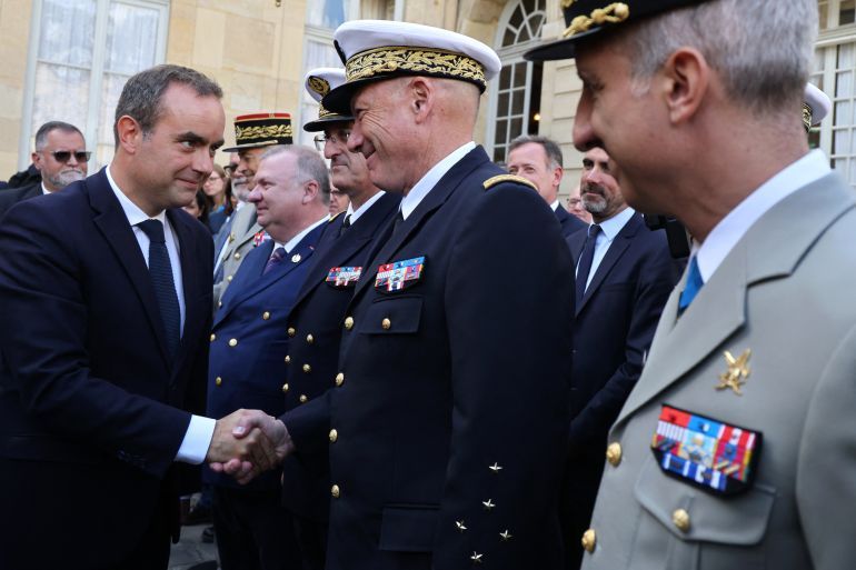 France's newly-appointed Prime Minister and former Minister of Armed Forces Sebastien Lecornu (L) is congratulated by French generals at the end of the handover ceremony at the Hotel Matignon in Paris on September 10, 2025.