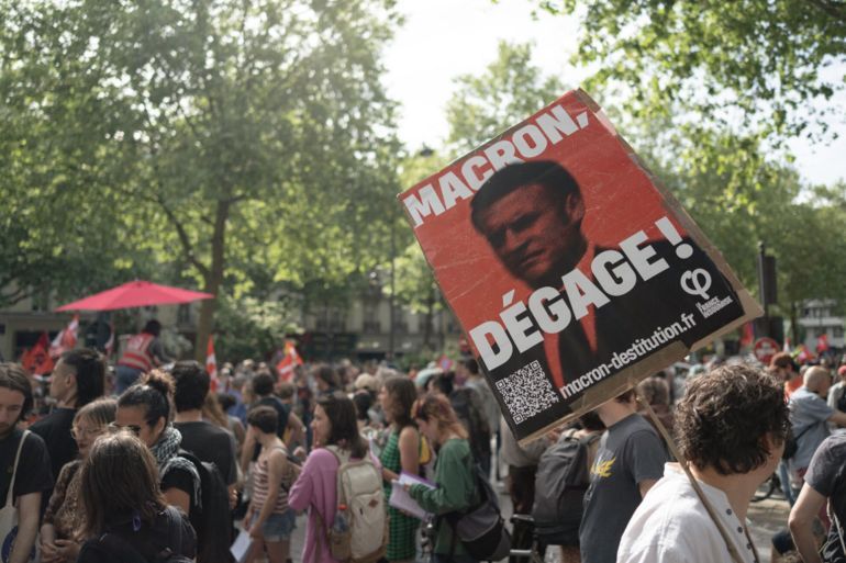 A man holds a sign demanding the impeachment of French president Emmanuel Macron during a protest in Rennes in the Ille-et-Vilaine department of France on May 1st, 2025. (Photo by Nicolas Hasson-Fauré / Hans Lucas / Hans Lucas via AFP) (Photo by NICOLAS HASSON-FAURE/Hans Lucas/AFP via Getty Images)