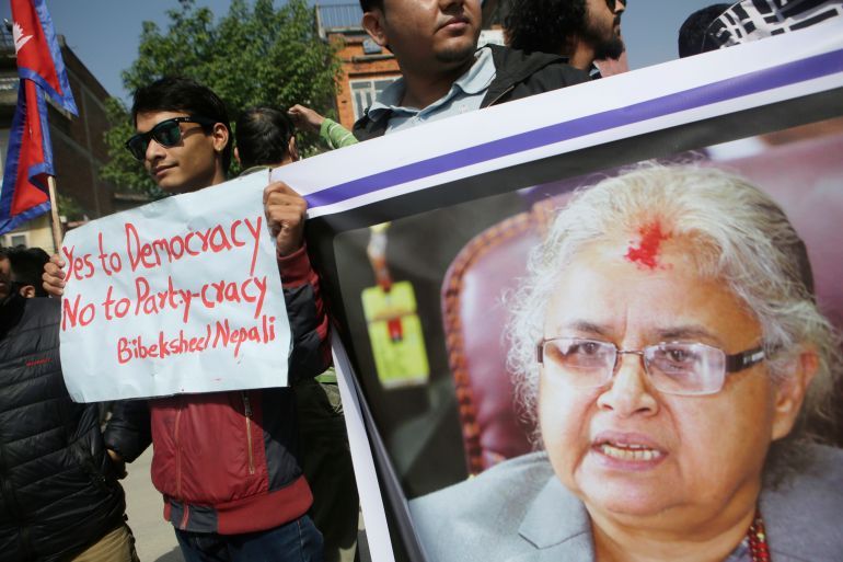 Supporters of Bibeksheel Nepali party hold a portrait of the Supreme Court Chief Justice Sushila Karki during a protest against her suspension in Kathmandu, Nepal, Monday, May 1, 2017. Karki, Nepal's first female judge to head the Supreme Court, has been suspended after an impeachment motion was signed by parliament members. (AP Photo/Niranjan Shrestha)