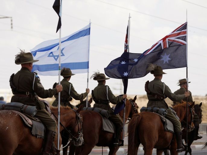 Members of the Australian Light Horse Association hold Australian and Israeli flags as they ride horses during a cavalry parade as part of events marking the centenary of the