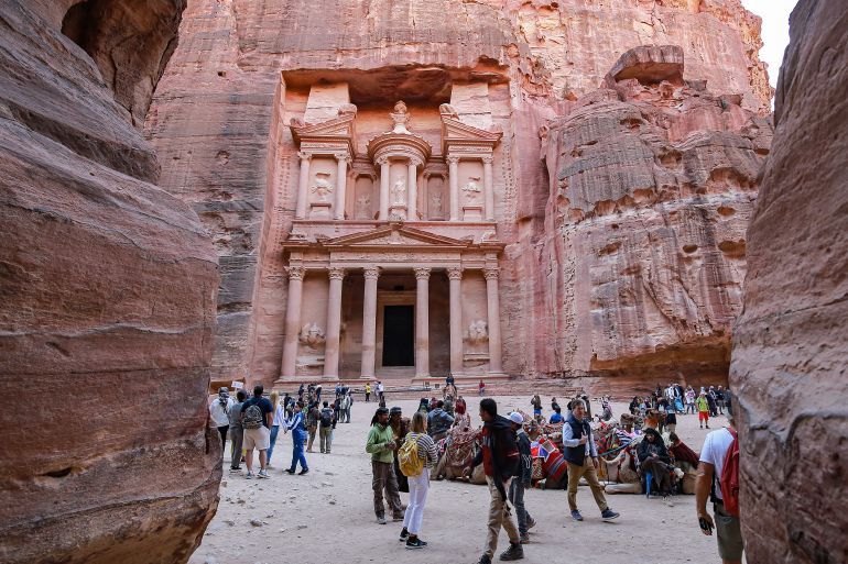 Visitors tour near the Treasury at the ruins of the ancient Nabatean city of Petra in southern Jordan on December 12, 2022. After years in which the Covid pandemic turned the storied