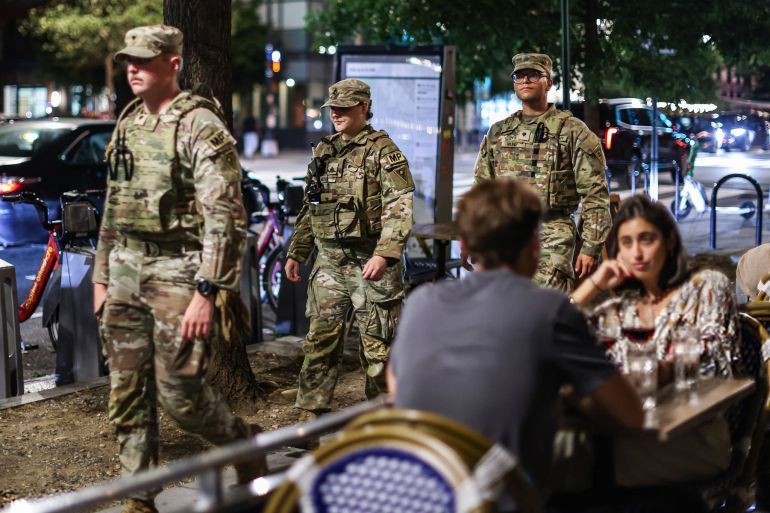 Members of the Ohio National Guard patrol near diners on 14th Street in Washington, DC, US, on Saturday, Aug. 23, 2025. National Guard troops deployed to Washington, DC, will now carry weapons, the Pentagon said, signaling a more aggressive posture after President Donald Trump warned he's
