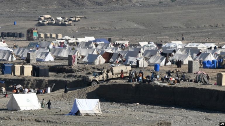 لاجئون أفغان يجلسون خارج خيامهم في مخيم مؤقت لدى وصولهم من باكستان بالقرب من الحدود الأفغانية الباكستانية في تورخام بإقليم ننكرهار مصدر الصورة (راديو فري يوروب)
