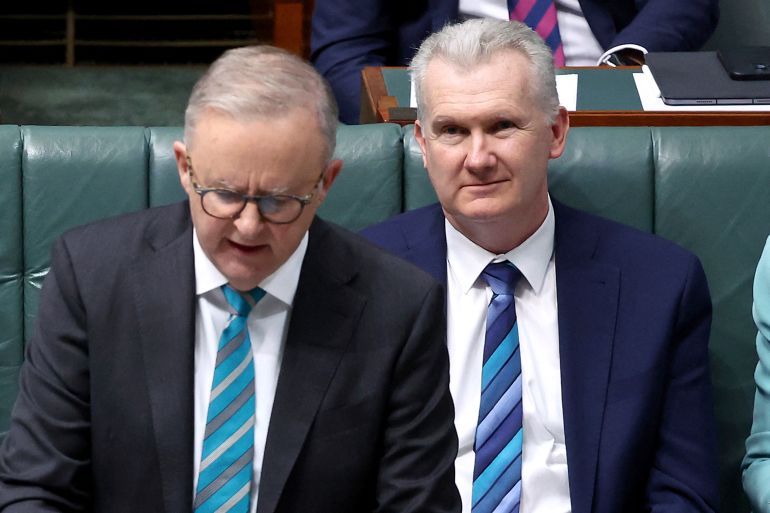 This picture taken on June 27, 2024 shows Australian Home Affairs Minister Tony Burke (R) listening to Australian Prime Minister Anthony Albanese speaking at the House of Representatives at Parliament House in Canberra.