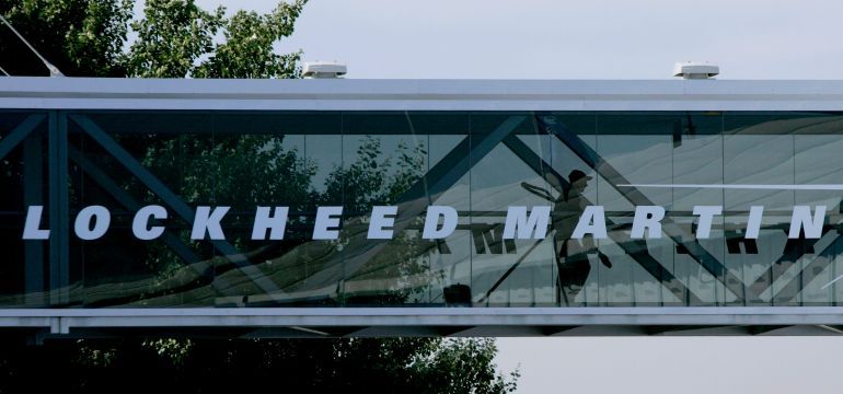 FILE - A man walks past a Lockheed Martin logo as he walks through a section of the company's chalet bridging a road at Farnborough International Airshow in Farnborough, southern England, July 19, 2006. (AP Photo/Matt Dunham, File)