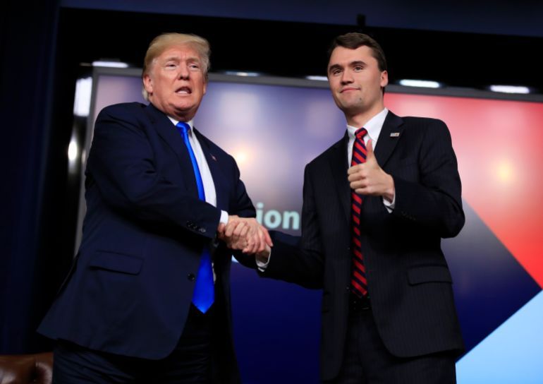 FILE - President Donald Trump shakes hands with moderator Charlie Kirk, during a Generation Next White House forum at the Eisenhower Executive Office Building on the White House complex in Washington, Thursday, March 22, 2018. (AP Photo/Manuel Balce Ceneta, File)