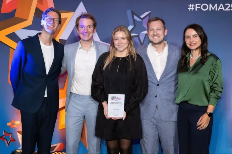 The i Paper executive editor Mark Davies, associate head of news Zoe Drewett and digital director Nick Petrie (centre three, left to right) pick up the Website of the Year (National/International) award at the Future of Media Awards 2025, alongside host Robin Morgan and PushPushGo CEO Renata Okrajni. Picture: ASV Photography for Press Gazette