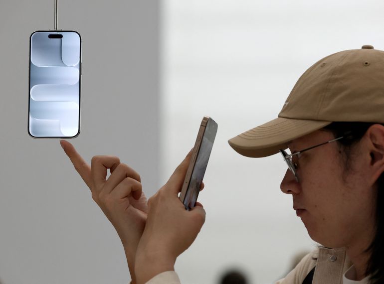 CUPERTINO, CALIFORNIA - SEPTEMBER 09: An attendee inspects a new Apple iPhone Air displayed during an Apple special event at Apple headquarters on September 9, 2025 in Cupertino, California. Apple unveiled a new generation of iPhones, updated Apple Watches, and AirPods during a special event at its headquarters. Justin Sullivan/Getty Images/AFP (Photo by JUSTIN SULLIVAN / GETTY IMAGES NORTH AMERICA / Getty Images via AFP)