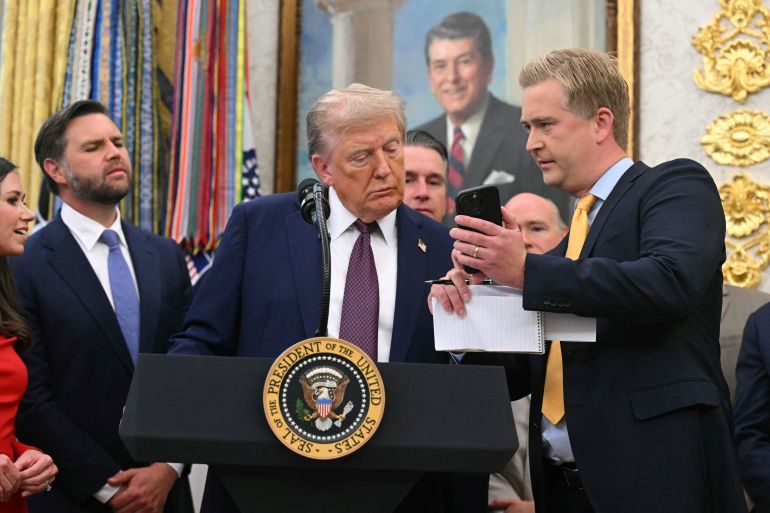 Fox News reporters Peter Doocy shows US President Donald Trump his phone as makes an announcement in the Oval Office of the White House in Washington, DC, on September 2, 2025.
